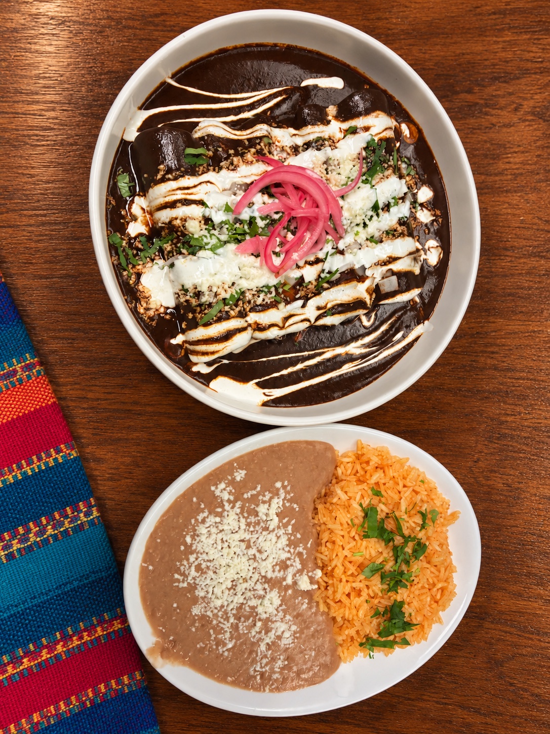 Enmoladas with rice, refried beans, crema and pickled onion
